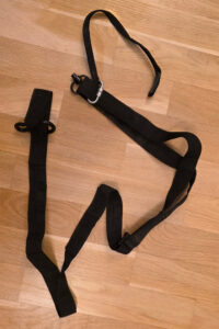There isn’t much to say about the strap itself. It consists of a very long piece of webbing that ends in a loop for a carabiner. Since I wasn't sure of the exact height required, I sewed three additional loops into the main webbing to serve as connection points for shortening the strap. At the shortest position, the goal was to stabilize the lens while it sat at the top; if I missed the correct length with the sewn loops, I planned to simply tie it off. In addition to the loops, I installed a standard length adjuster salvaged from a disassembled Leofoto strap. At maximum extension, I wanted the webbing to reach the ground, though it ended up being 10 cm too short. The strap terminates with a QD mount and a secondary safety leash using a PD anchor.